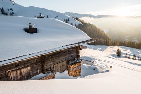 Tief verschneite Hütte im Brixental
